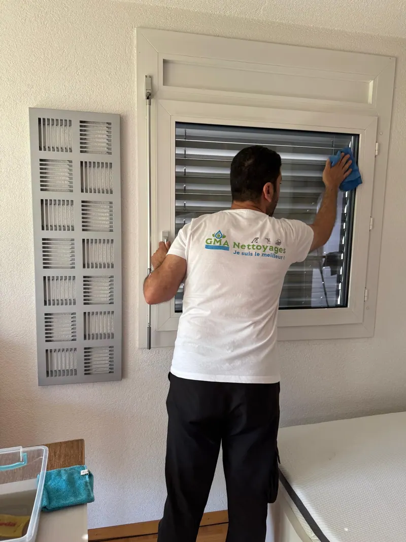 Gazwan nettoie une surface vitrée.